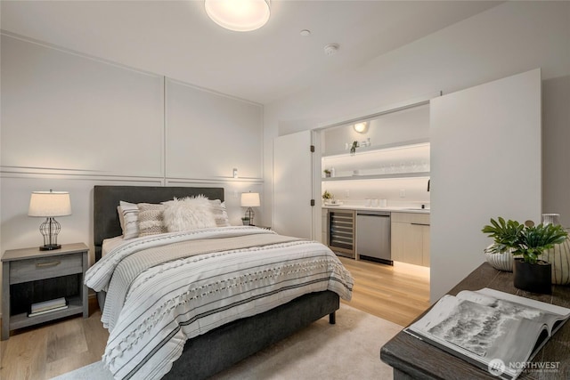 bedroom with beverage cooler, refrigerator, and light wood-type flooring