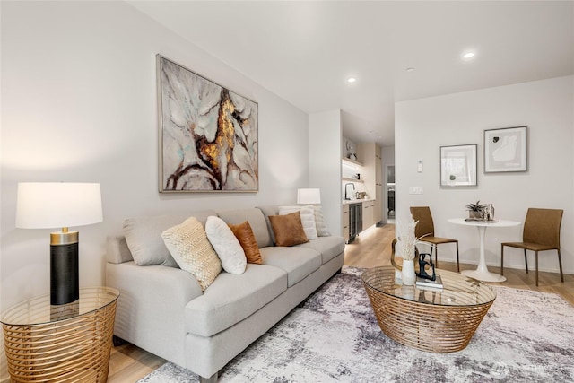 living room with recessed lighting, baseboards, and light wood-style floors