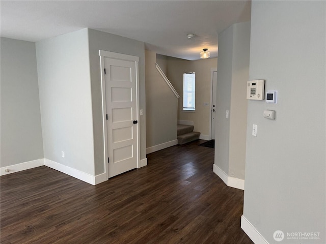 interior space with baseboards, dark wood-style floors, and stairs