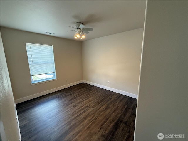 unfurnished room featuring dark wood finished floors, visible vents, baseboards, and ceiling fan