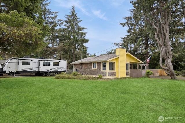 view of front of home with a chimney and a front lawn