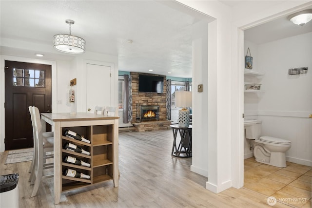 dining space with a stone fireplace, wood finished floors, and baseboards