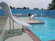 community pool featuring a water slide and fence