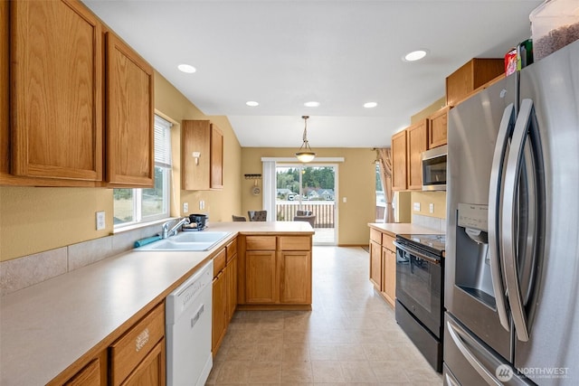 kitchen with a peninsula, hanging light fixtures, plenty of natural light, stainless steel appliances, and a sink