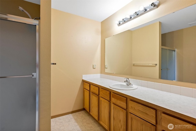 bathroom with tile patterned floors, a shower stall, vanity, and baseboards