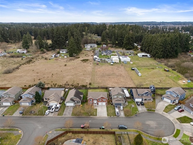 drone / aerial view with a residential view and a wooded view