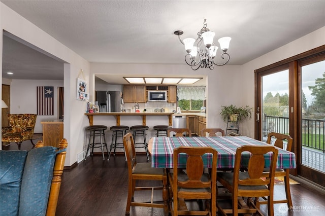 dining room with baseboards, dark wood-type flooring, and an inviting chandelier