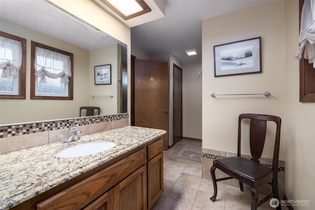 bathroom with backsplash, vanity, and tile patterned flooring