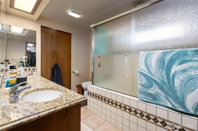 full bath with tile patterned flooring, toilet, an enclosed shower, and vanity