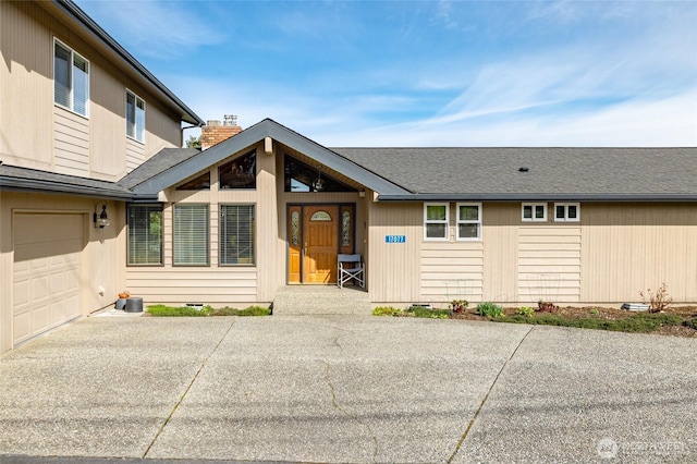 view of front of house featuring concrete driveway, an attached garage, crawl space, and a chimney