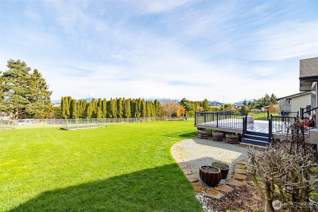 view of yard with a deck and fence