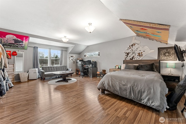 bedroom with vaulted ceiling and wood finished floors