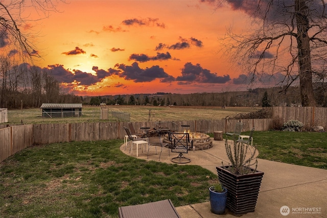 view of yard featuring a patio, fence, an outbuilding, and an outdoor fire pit