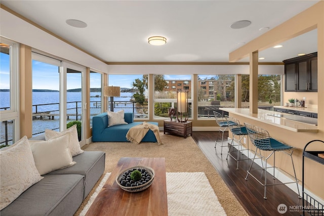 sunroom featuring a water view