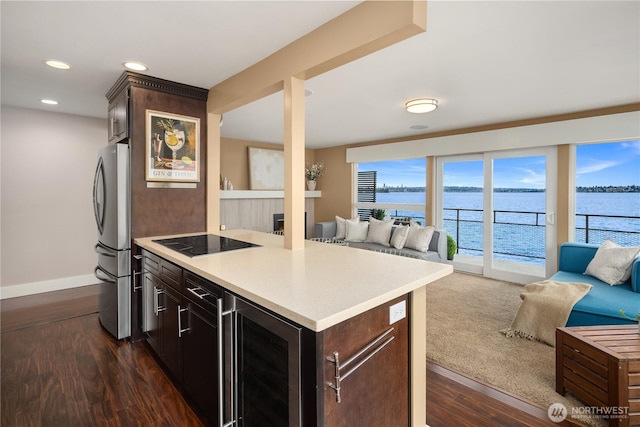 kitchen featuring freestanding refrigerator, black electric stovetop, open floor plan, and wine cooler