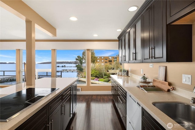 kitchen featuring dishwasher, recessed lighting, dark wood-style floors, black electric cooktop, and a sink