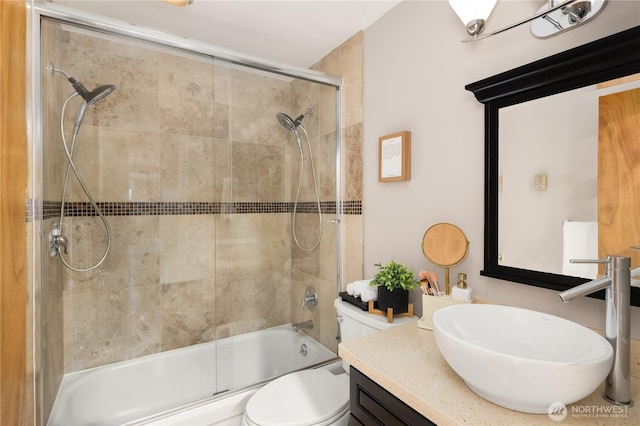 full bath with vanity, toilet, and combined bath / shower with glass door