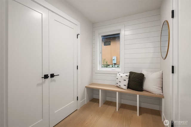 mudroom featuring wooden walls and light wood-style floors