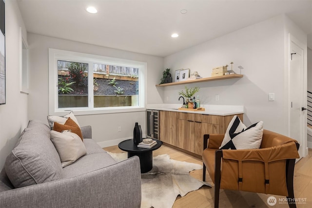 sitting room featuring recessed lighting, baseboards, beverage cooler, and light wood finished floors