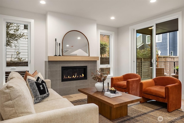 living area with recessed lighting and a tile fireplace