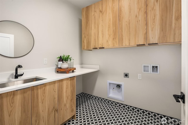 clothes washing area featuring electric dryer hookup, washer hookup, cabinet space, and a sink