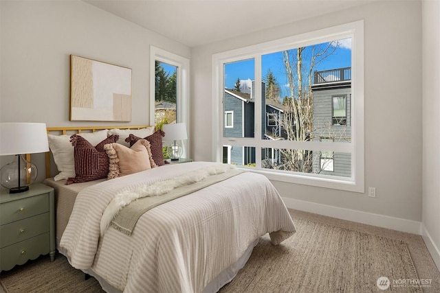 carpeted bedroom with baseboards and multiple windows