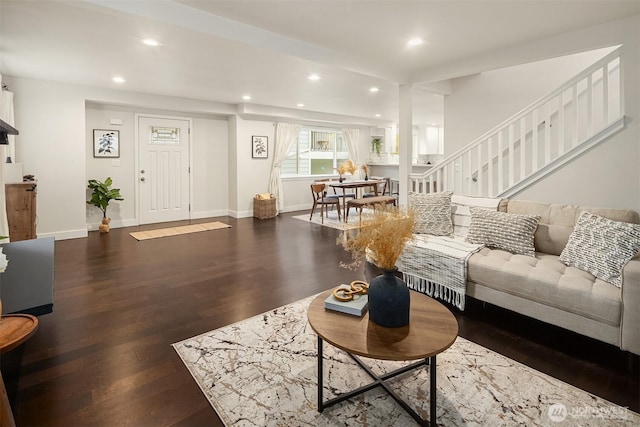 living room with recessed lighting, baseboards, wood finished floors, and stairs