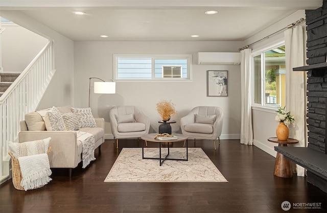 living room with dark wood-type flooring, baseboards, stairs, a wall unit AC, and recessed lighting