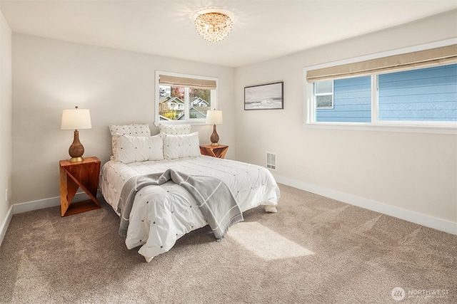 carpeted bedroom featuring visible vents and baseboards