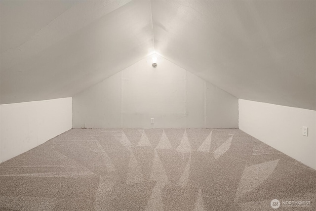 additional living space with carpet floors and vaulted ceiling