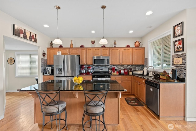 kitchen with a sink, backsplash, a kitchen bar, and stainless steel appliances