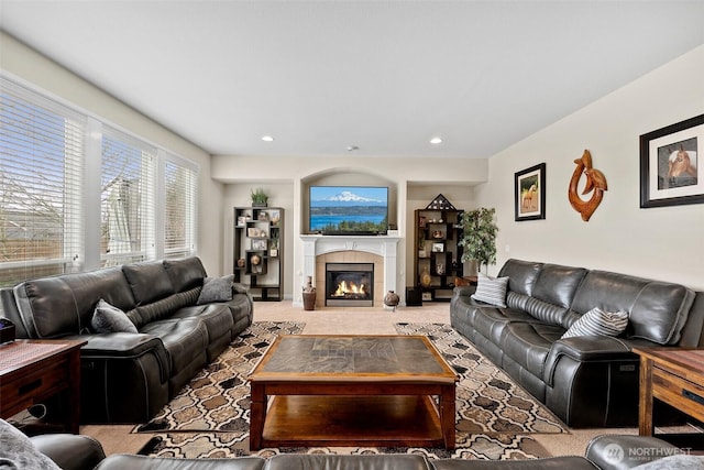 living room with recessed lighting, light colored carpet, and a tile fireplace