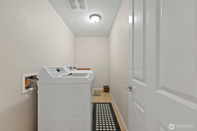 washroom featuring washer and dryer, laundry area, and baseboards