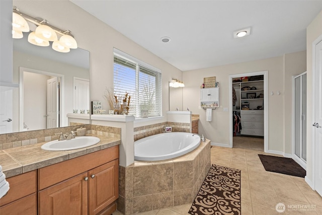 bathroom featuring a walk in closet, a shower stall, tile patterned flooring, a bath, and vanity