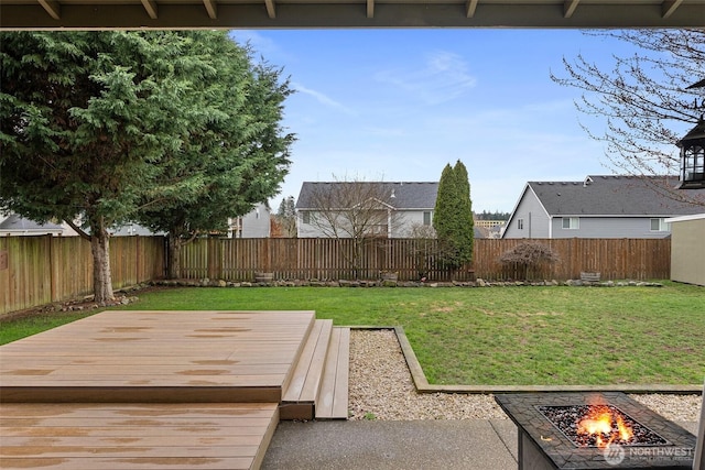 view of yard with a wooden deck, an outdoor fire pit, and a fenced backyard