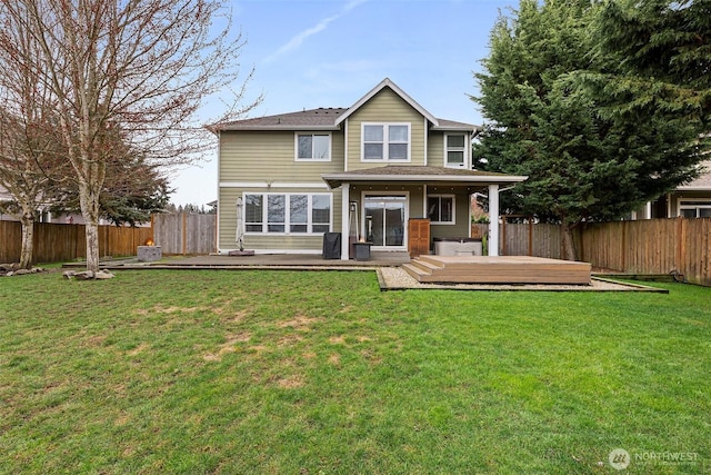 back of property with a yard, a fenced backyard, and a wooden deck