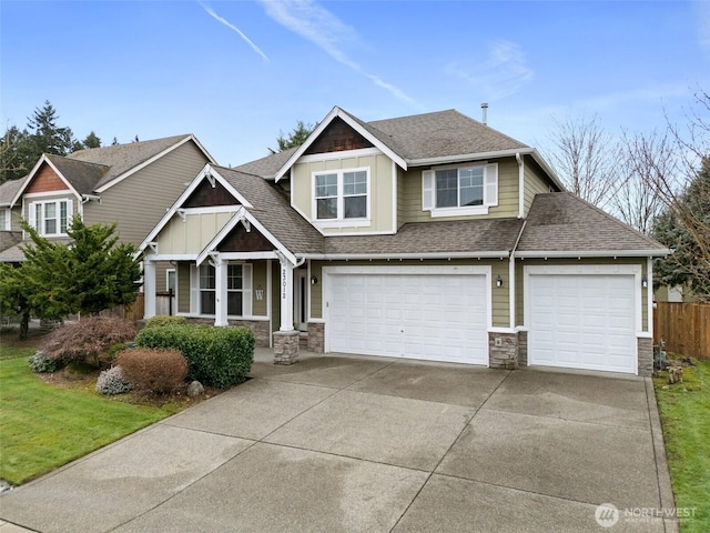 craftsman house with concrete driveway, stone siding, board and batten siding, and roof with shingles