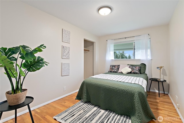 bedroom featuring a closet, baseboards, and wood finished floors