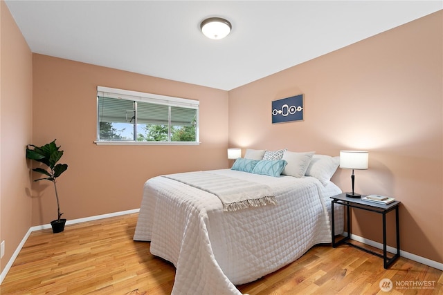 bedroom with wood finished floors and baseboards