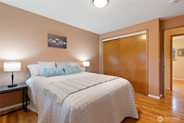 bedroom featuring light wood-style floors, a closet, and baseboards