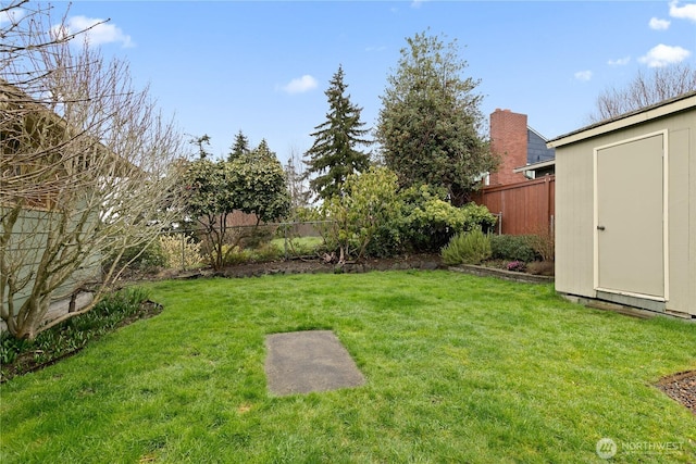 view of yard with an outdoor structure, a storage unit, and a fenced backyard