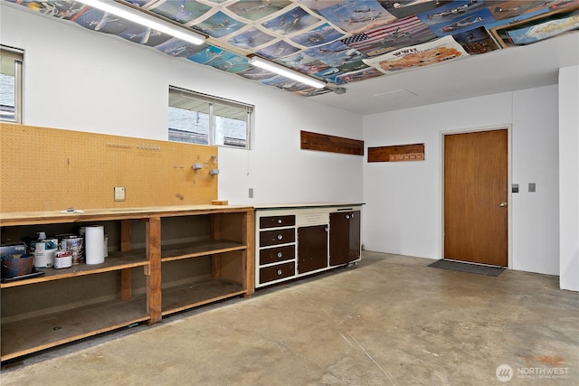 miscellaneous room featuring a workshop area and concrete flooring