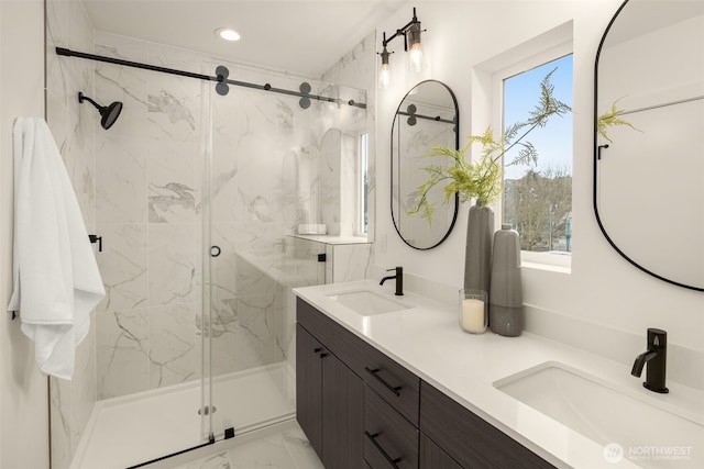 bathroom featuring a marble finish shower, recessed lighting, marble finish floor, and a sink