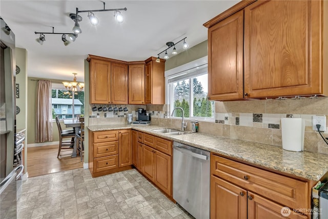 kitchen featuring stainless steel dishwasher, decorative backsplash, plenty of natural light, and a sink