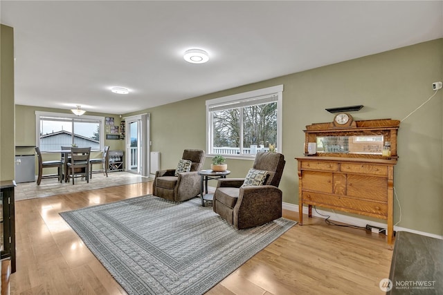 living area with light wood-style flooring and baseboards