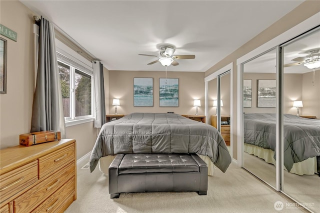 bedroom featuring light carpet, baseboards, two closets, and ceiling fan