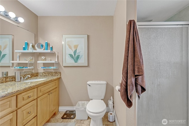 bathroom with baseboards, toilet, a stall shower, tile patterned floors, and vanity