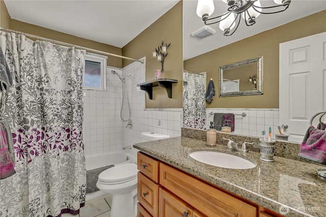 full bathroom featuring shower / bath combo with shower curtain, toilet, vanity, a notable chandelier, and tile walls