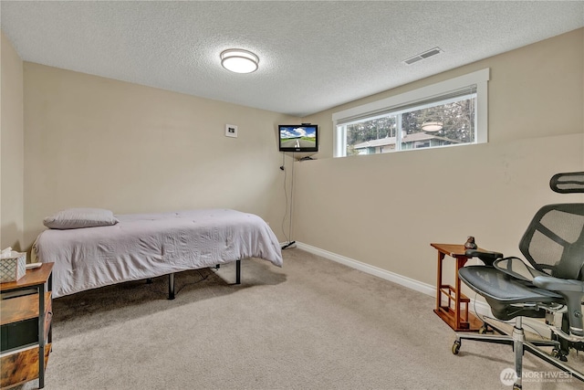 carpeted bedroom featuring visible vents, a textured ceiling, and baseboards