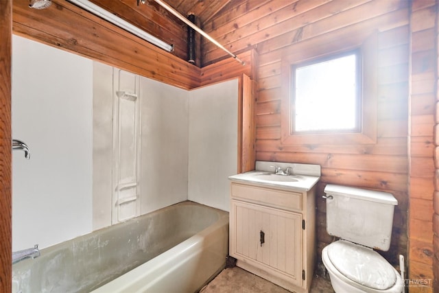 full bathroom with wooden walls, toilet, vanity, and bathtub / shower combination